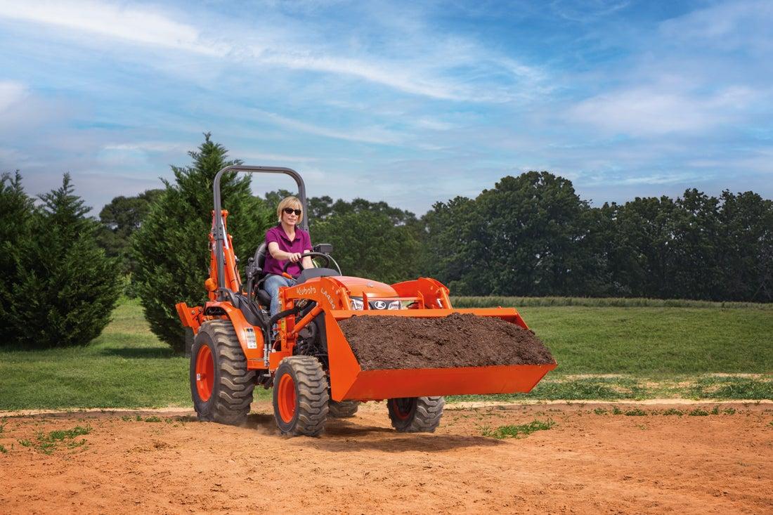 Woman moving dirt with tractor