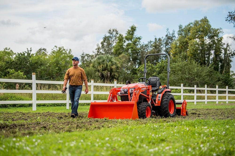 Man walking alongside tractor