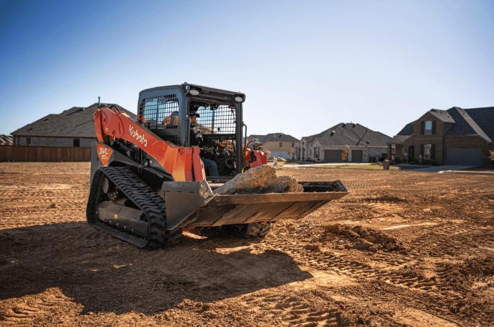 Track Loader moving slabs on rock