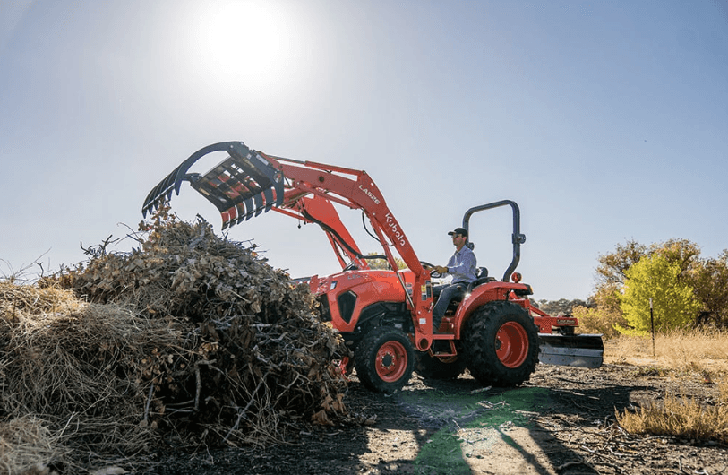 Tractor moving large debris onto pile