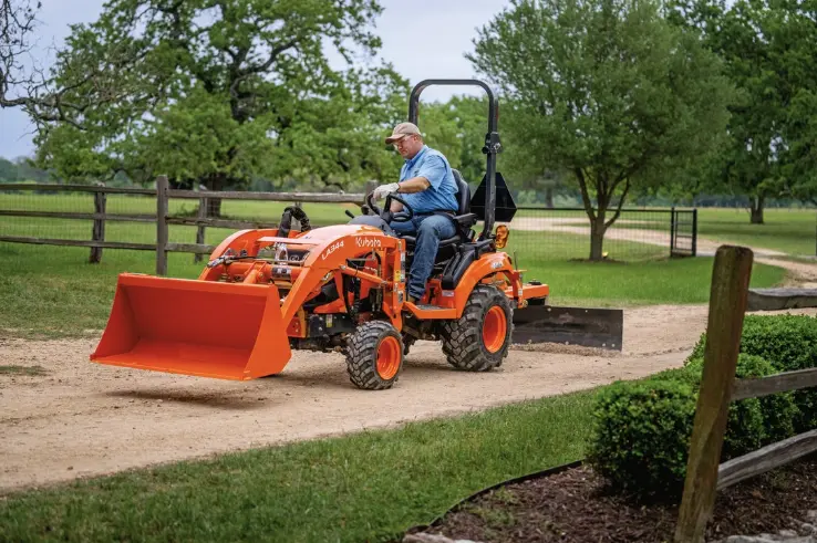Man using tractor to level out the driveway