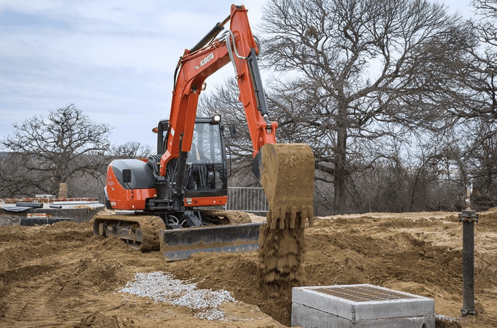 KX080 dumping dirt into a ditch