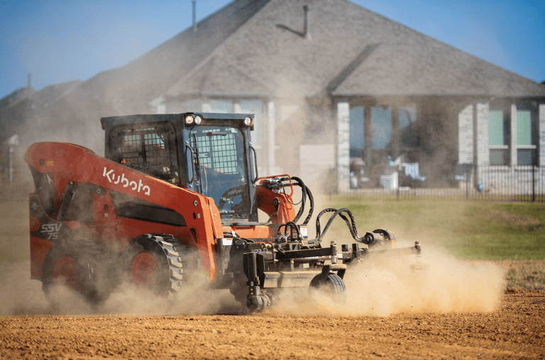 Skid Steer leveling out terrain on site
