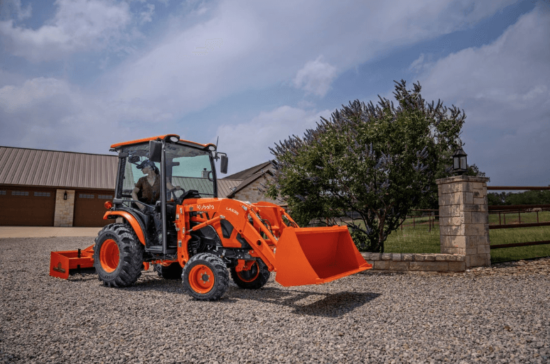 Person driving tractor on gravel driveway