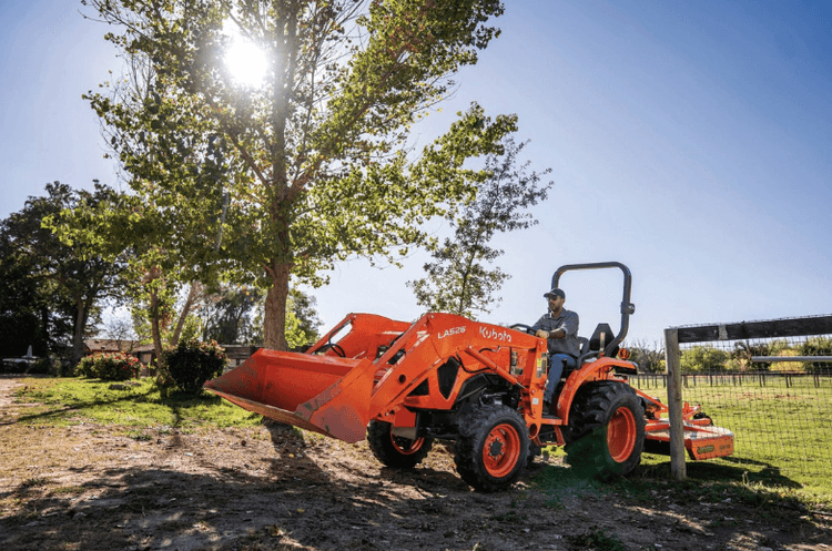 Kubota tractor driving through a gate