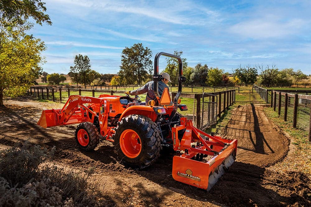 Man operating compact tractor
