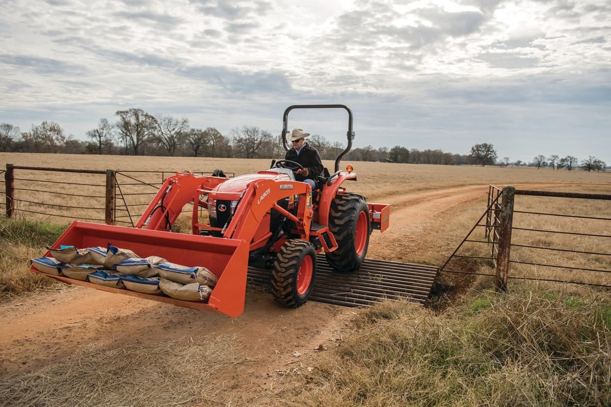 Man operating compact tractor