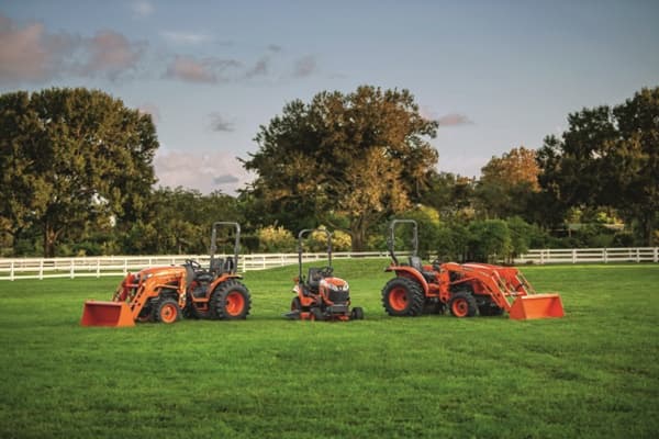 A lineup of Kubota Tractors on a field