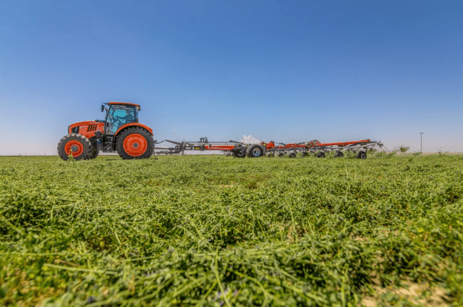 Kubota M7-134 tractor pulling a TE14515C implement across a hay field